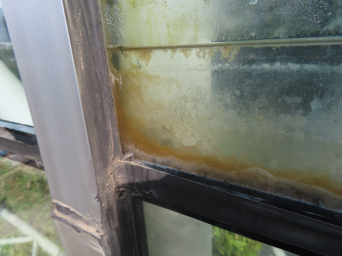 Glass façade with edge damage and visible cracking requiring façade inspection